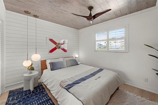 bedroom featuring light hardwood / wood-style floors, wooden walls, wooden ceiling, ceiling fan, and ornamental molding