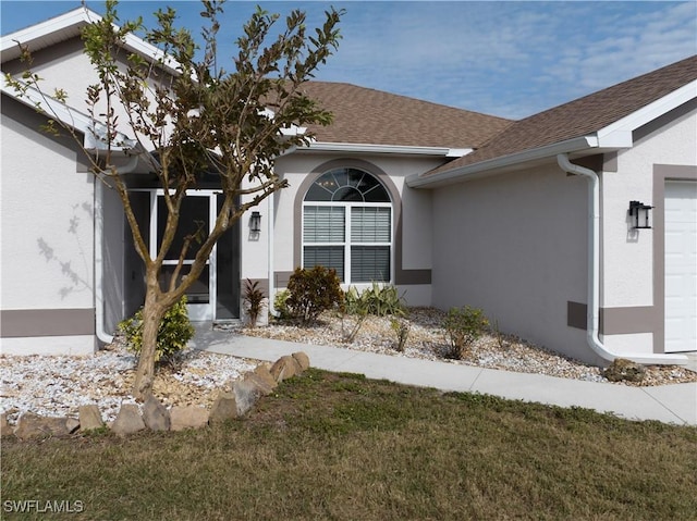 property entrance featuring a garage and a yard