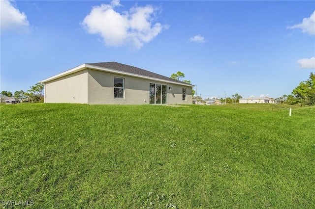 rear view of property featuring a yard