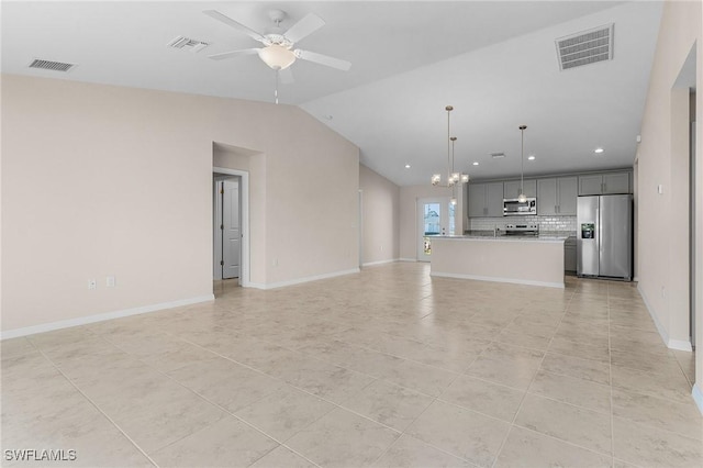 unfurnished living room featuring lofted ceiling, ceiling fan with notable chandelier, and light tile patterned floors