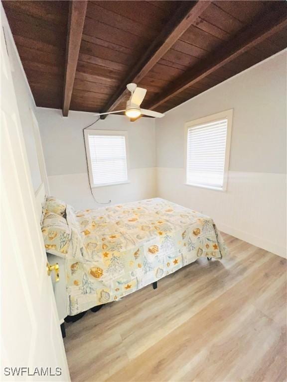 unfurnished bedroom featuring vaulted ceiling with beams, ceiling fan, wood-type flooring, and wood ceiling