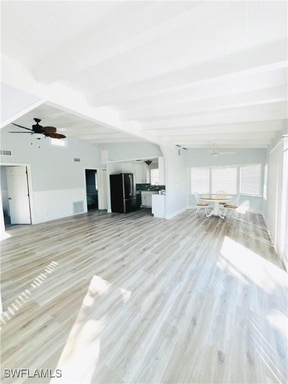 unfurnished living room with beam ceiling, light hardwood / wood-style flooring, and ceiling fan