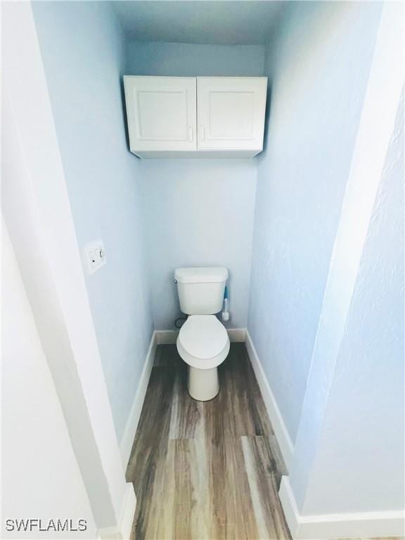 bathroom with hardwood / wood-style flooring and toilet