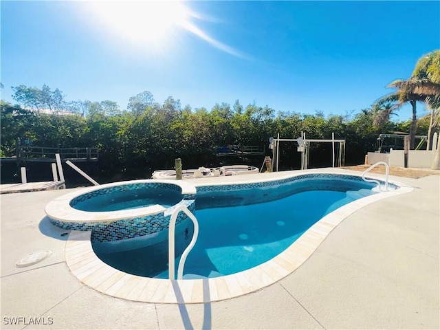 view of pool with an in ground hot tub and a patio