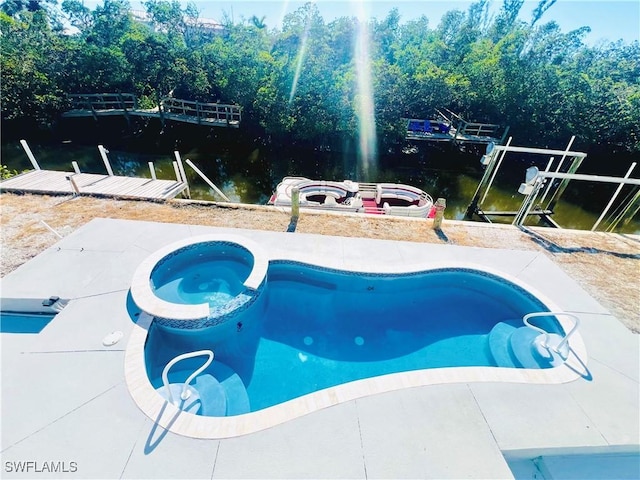 view of swimming pool with an in ground hot tub and a water view