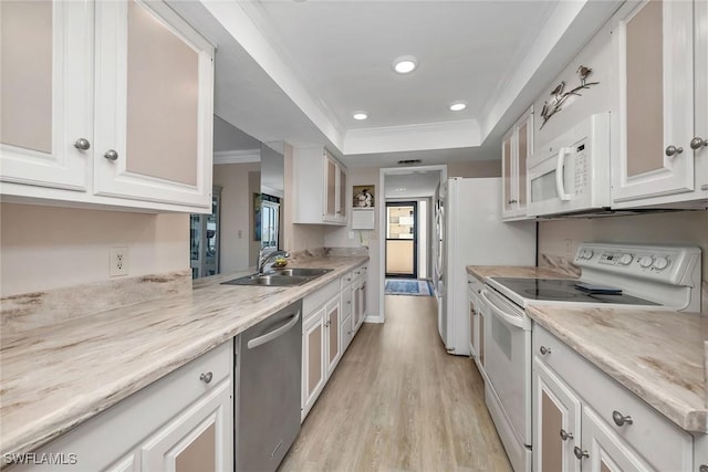 kitchen featuring a raised ceiling, sink, white cabinets, and white appliances