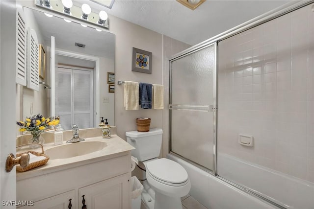 full bathroom featuring vanity, toilet, and bath / shower combo with glass door