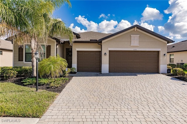 view of front of home featuring central air condition unit and a garage