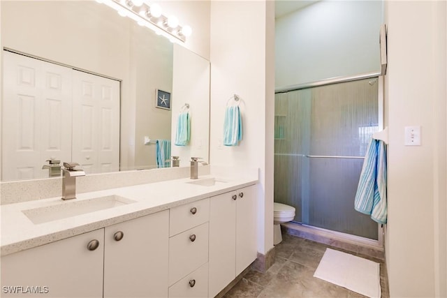 bathroom featuring vanity, toilet, and a shower with shower door