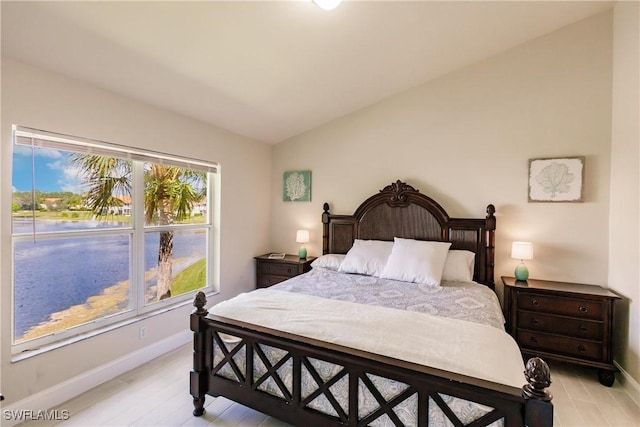 bedroom with lofted ceiling and light hardwood / wood-style flooring