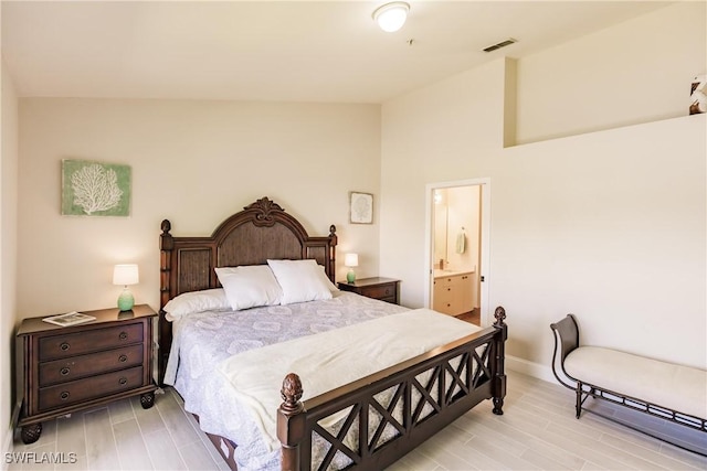 bedroom featuring lofted ceiling and connected bathroom