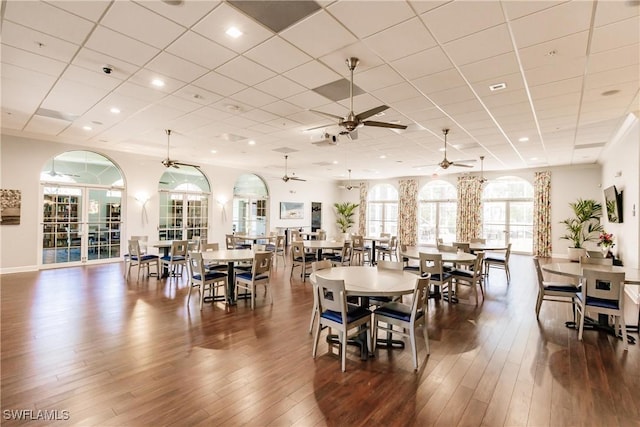 dining space featuring dark wood-type flooring, ceiling fan, and a paneled ceiling