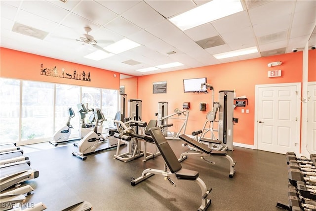 gym with a paneled ceiling and ceiling fan