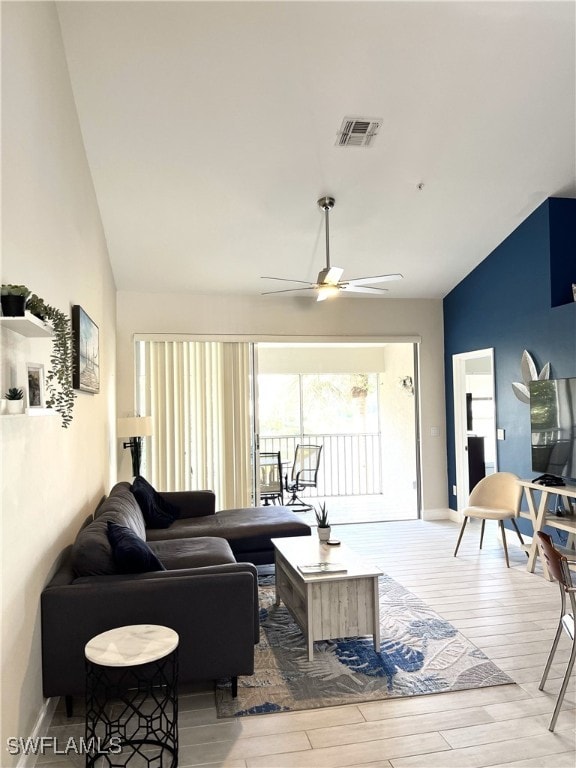 living room with ceiling fan, high vaulted ceiling, and light hardwood / wood-style flooring