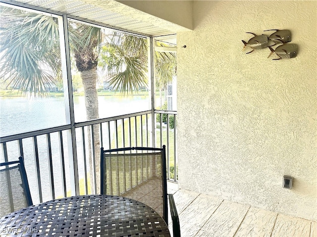 unfurnished sunroom featuring a water view