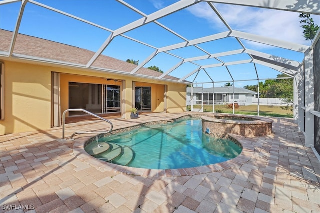 view of swimming pool with glass enclosure, a pool with connected hot tub, ceiling fan, and a patio