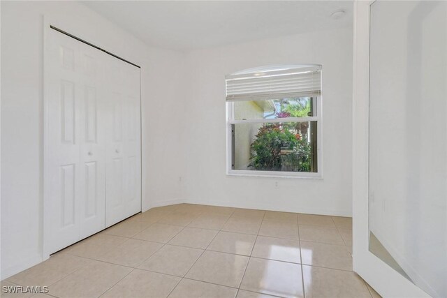 unfurnished bedroom featuring a closet and light tile patterned floors