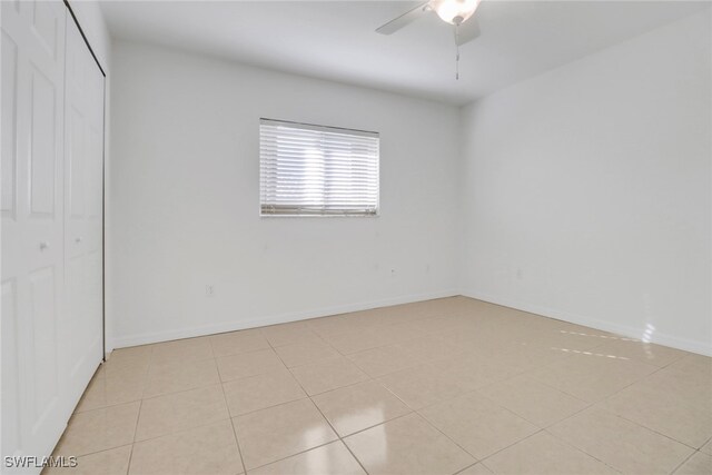 unfurnished bedroom with ceiling fan, light tile patterned floors, and a closet