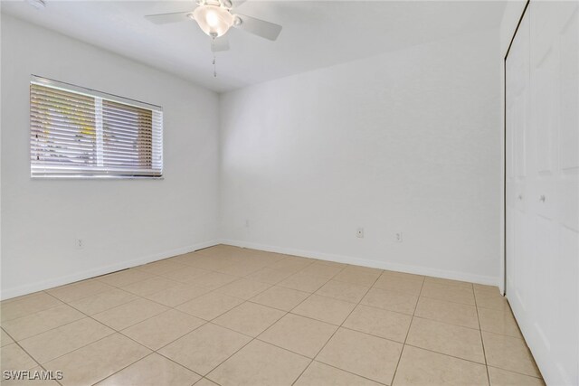 spare room with ceiling fan and light tile patterned flooring