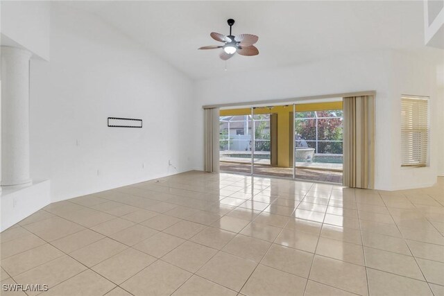 tiled empty room featuring ceiling fan and a towering ceiling