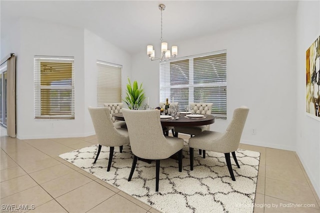 tiled dining room featuring baseboards and a chandelier