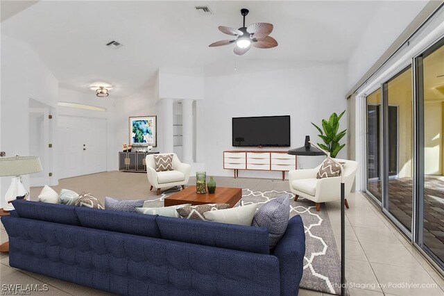 living room featuring light tile patterned floors, a ceiling fan, visible vents, and ornate columns