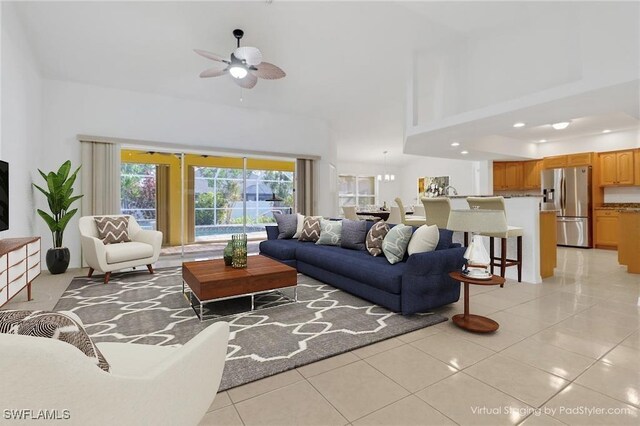 living room featuring light tile patterned floors, a high ceiling, and a ceiling fan