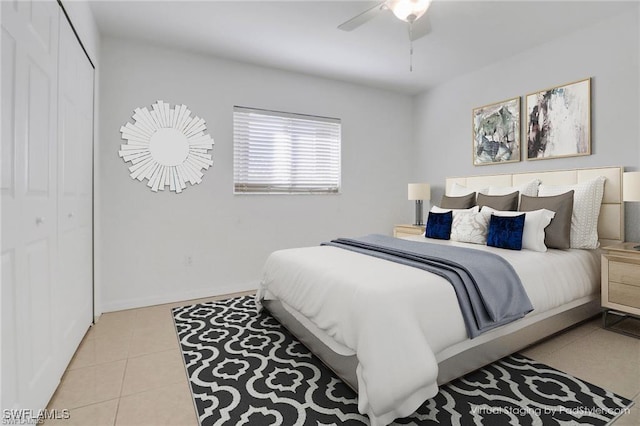 tiled bedroom with a ceiling fan, a closet, and baseboards