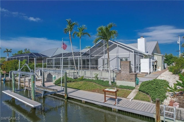 back of house featuring a lanai and a water view