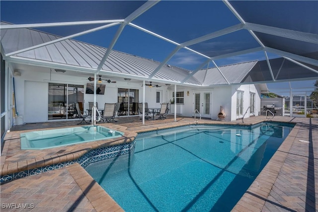 view of pool featuring an in ground hot tub, french doors, ceiling fan, glass enclosure, and a patio