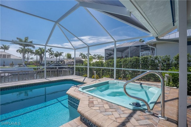 view of pool featuring a lanai and an in ground hot tub