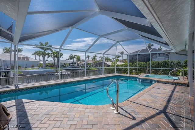 view of swimming pool with a lanai, a patio area, and an in ground hot tub