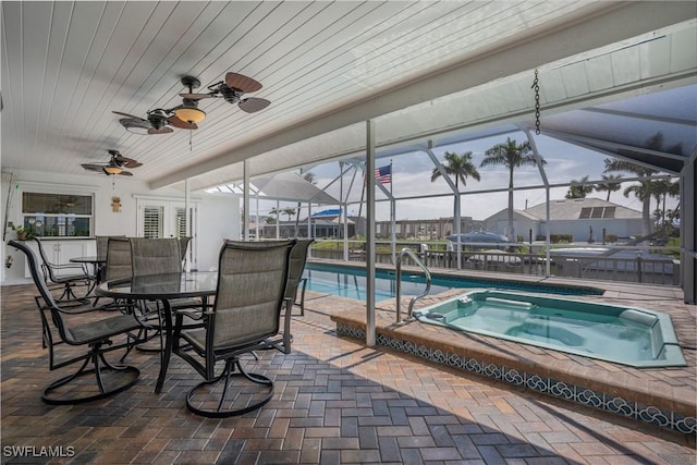 view of pool featuring a patio area, a lanai, and an in ground hot tub