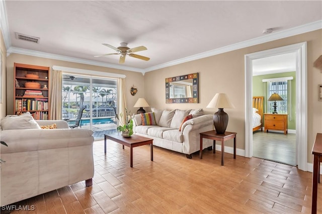 living room with ceiling fan and crown molding