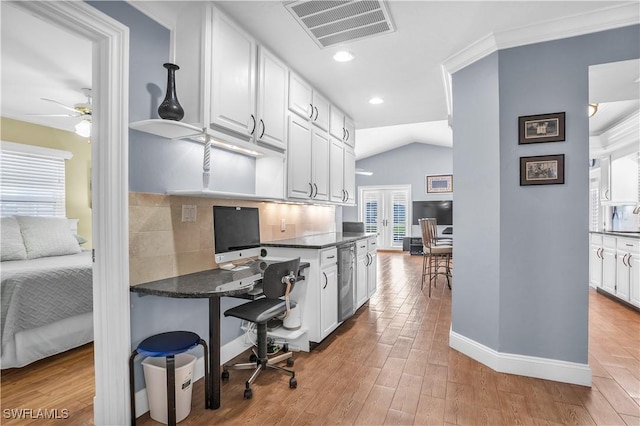 kitchen with lofted ceiling, crown molding, tasteful backsplash, light hardwood / wood-style floors, and white cabinetry