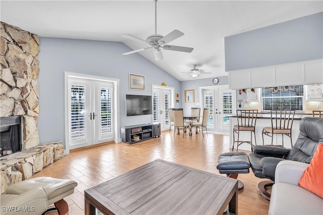 living room with a fireplace, french doors, vaulted ceiling, and ceiling fan