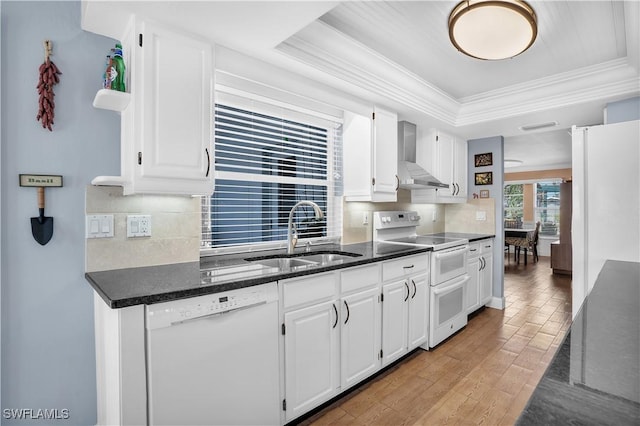 kitchen featuring white cabinets, wall chimney exhaust hood, and white appliances