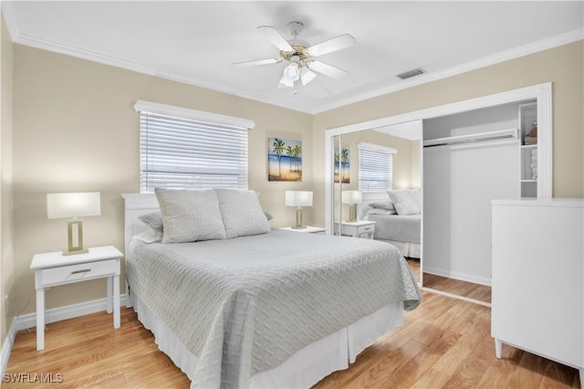 bedroom with ceiling fan, light wood-type flooring, multiple windows, and a closet