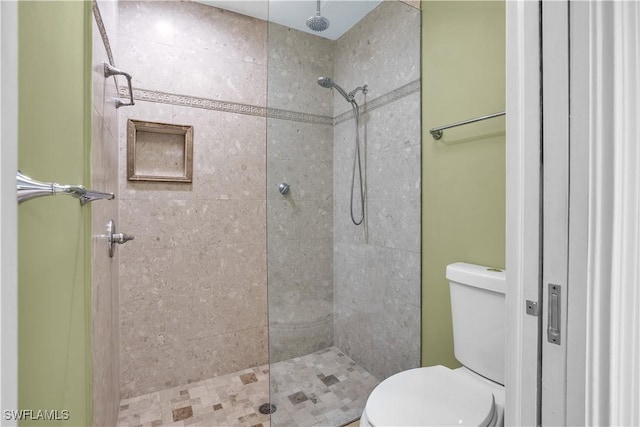 bathroom with toilet and a tile shower