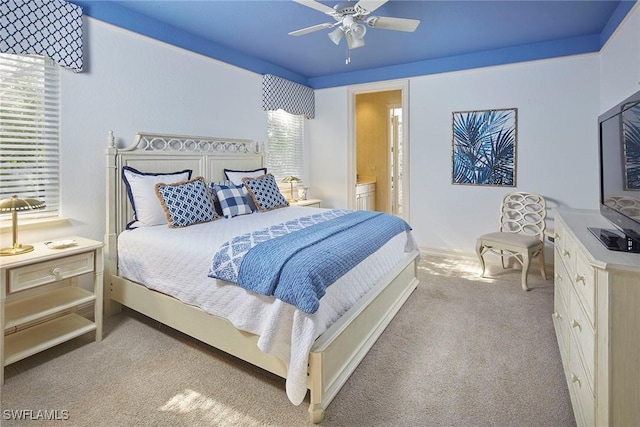 carpeted bedroom with ceiling fan and connected bathroom