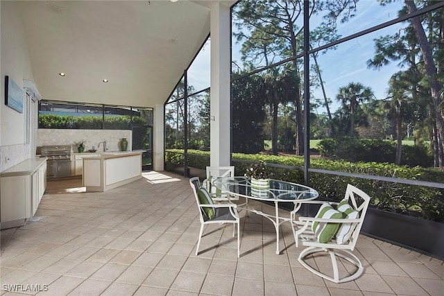 sunroom featuring lofted ceiling and sink