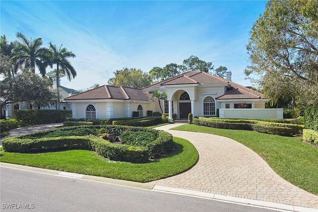 mediterranean / spanish-style home with a front yard