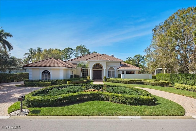 mediterranean / spanish house featuring a front yard