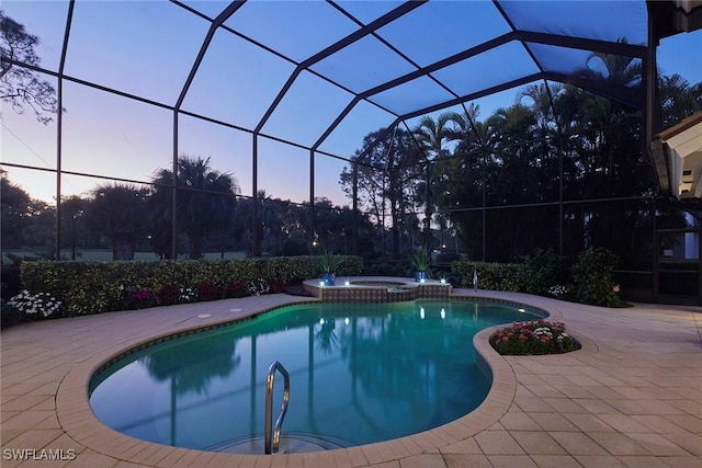 pool at dusk featuring a lanai, an in ground hot tub, and a patio