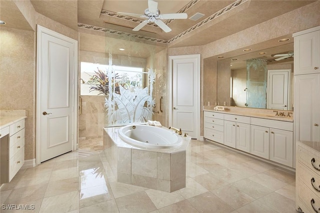 bathroom featuring vanity, ceiling fan, a raised ceiling, and tiled tub