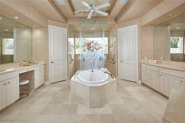 bathroom featuring vanity, a tray ceiling, ceiling fan, and tiled tub