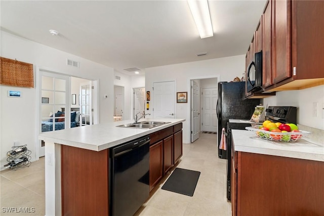 kitchen with a kitchen island with sink, sink, and black appliances