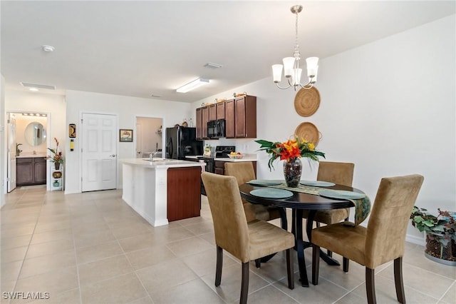 dining space featuring light tile patterned floors, sink, and a chandelier