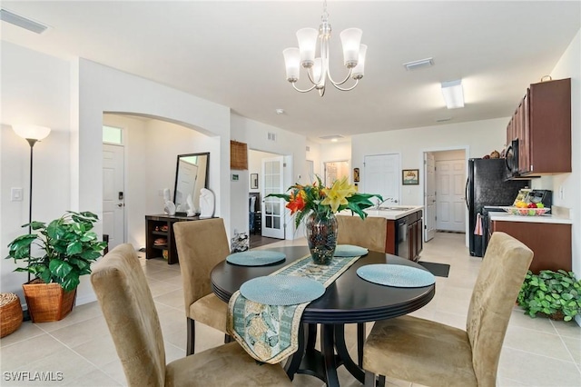 dining area with a chandelier, light tile patterned floors, and sink