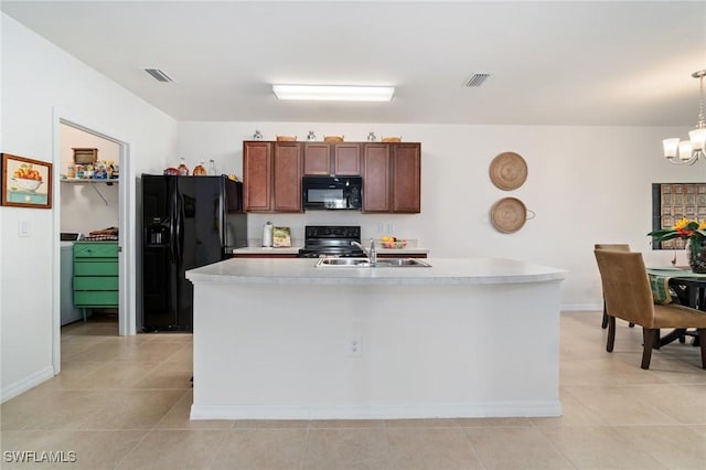 kitchen with sink, black appliances, decorative light fixtures, a chandelier, and an island with sink